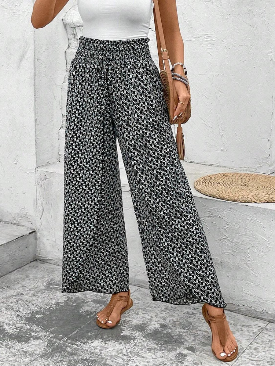 Black and white patterned palazzo pants with a smocked waist and tie detail.