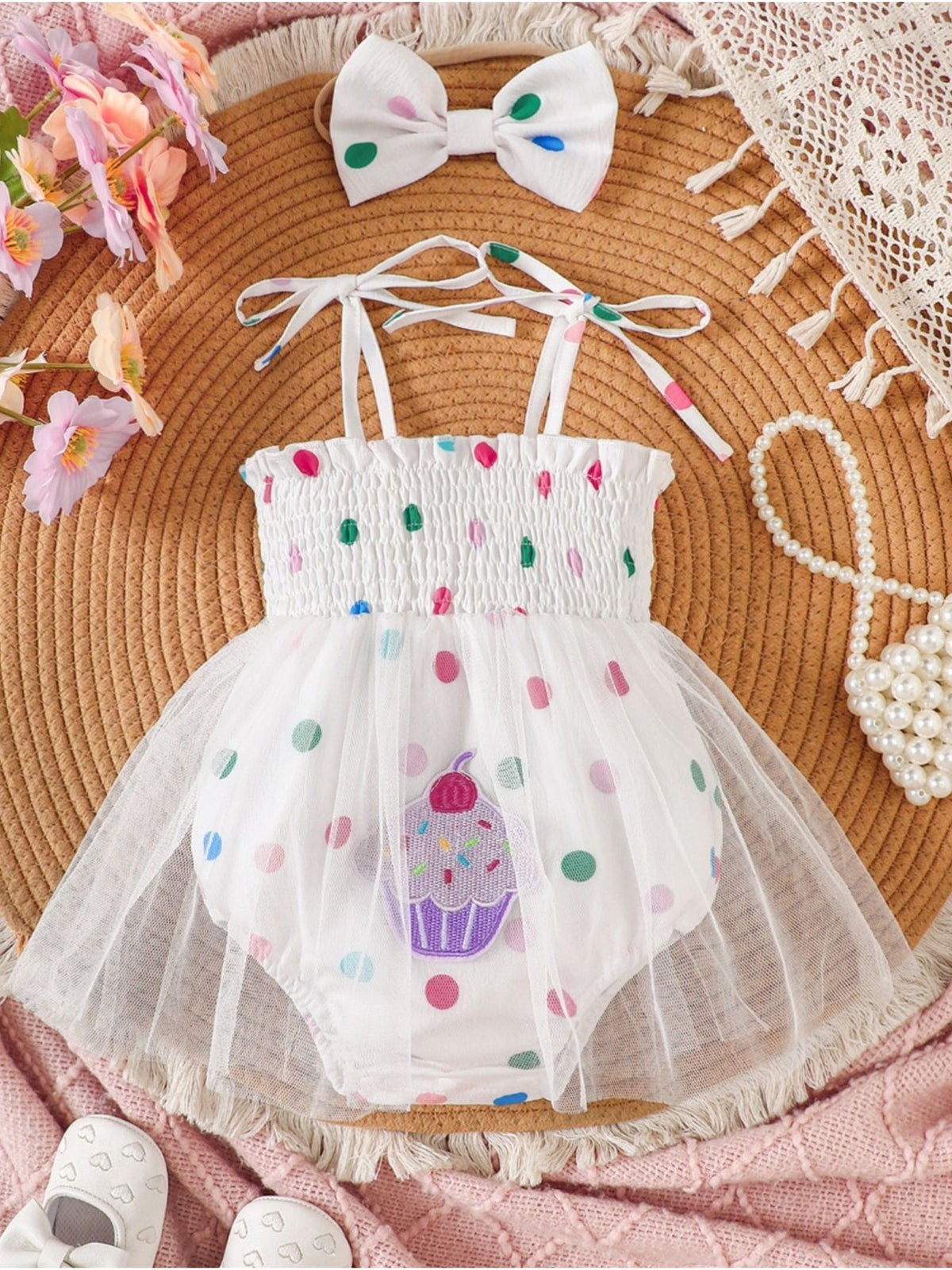 White smocked bodysuit dress with cupcake applique and polka dots, includes matching bow headband.