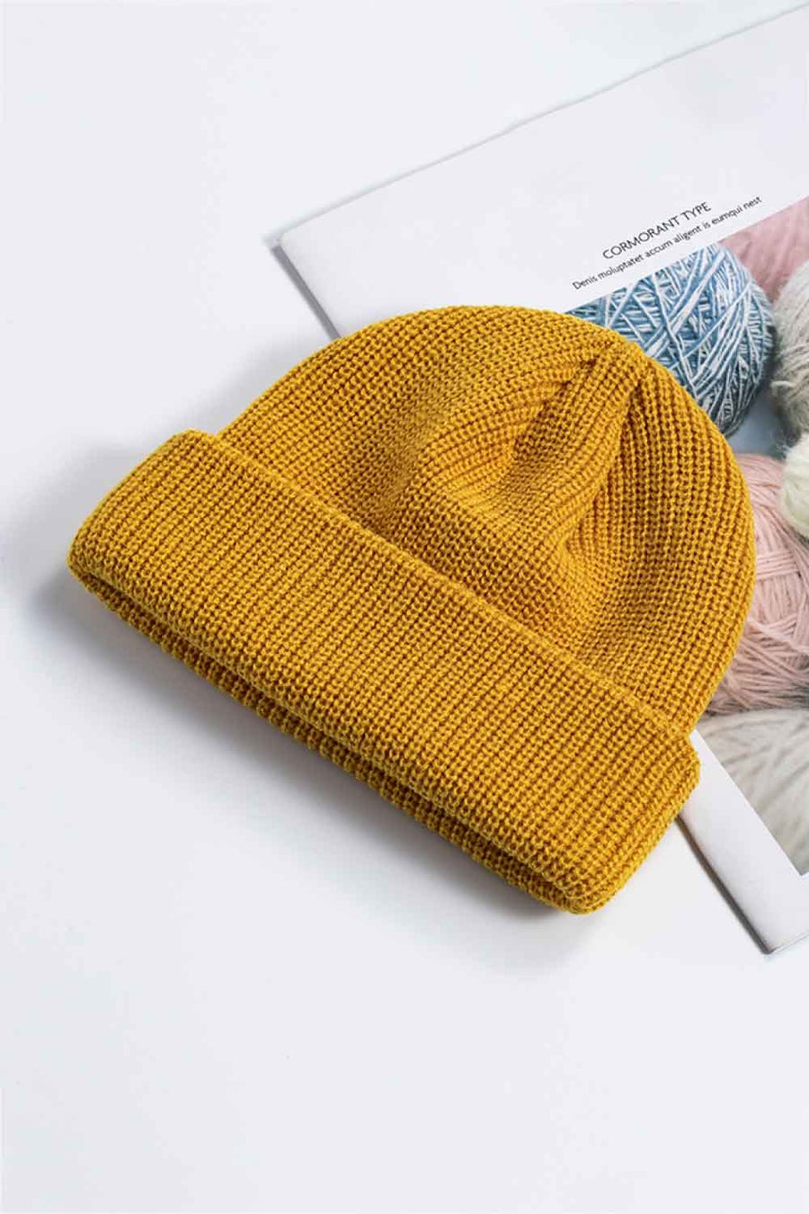 Mustard yellow ribbed knit beanie with a turn-up cuff.