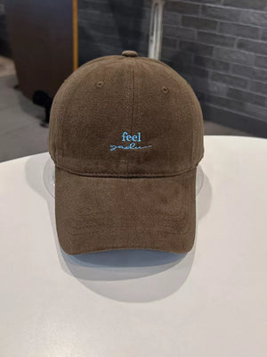 Brown baseball cap with blue embroidered text detail