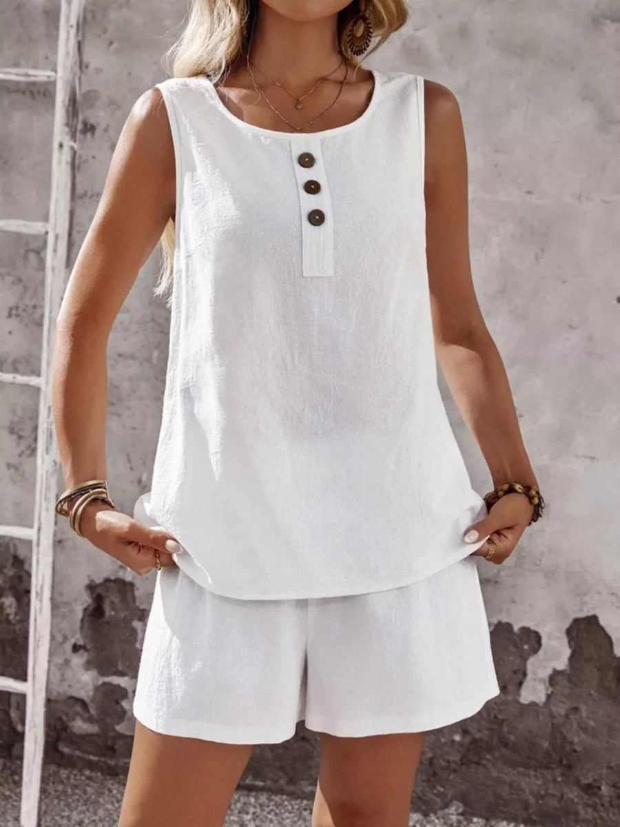 White cotton two-piece set with decorative buttons on the sleeveless top and matching shorts.