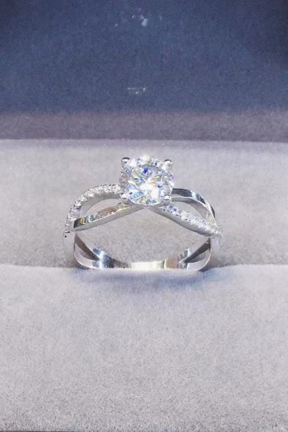Silver crisscross ring with diamond halo and center stone