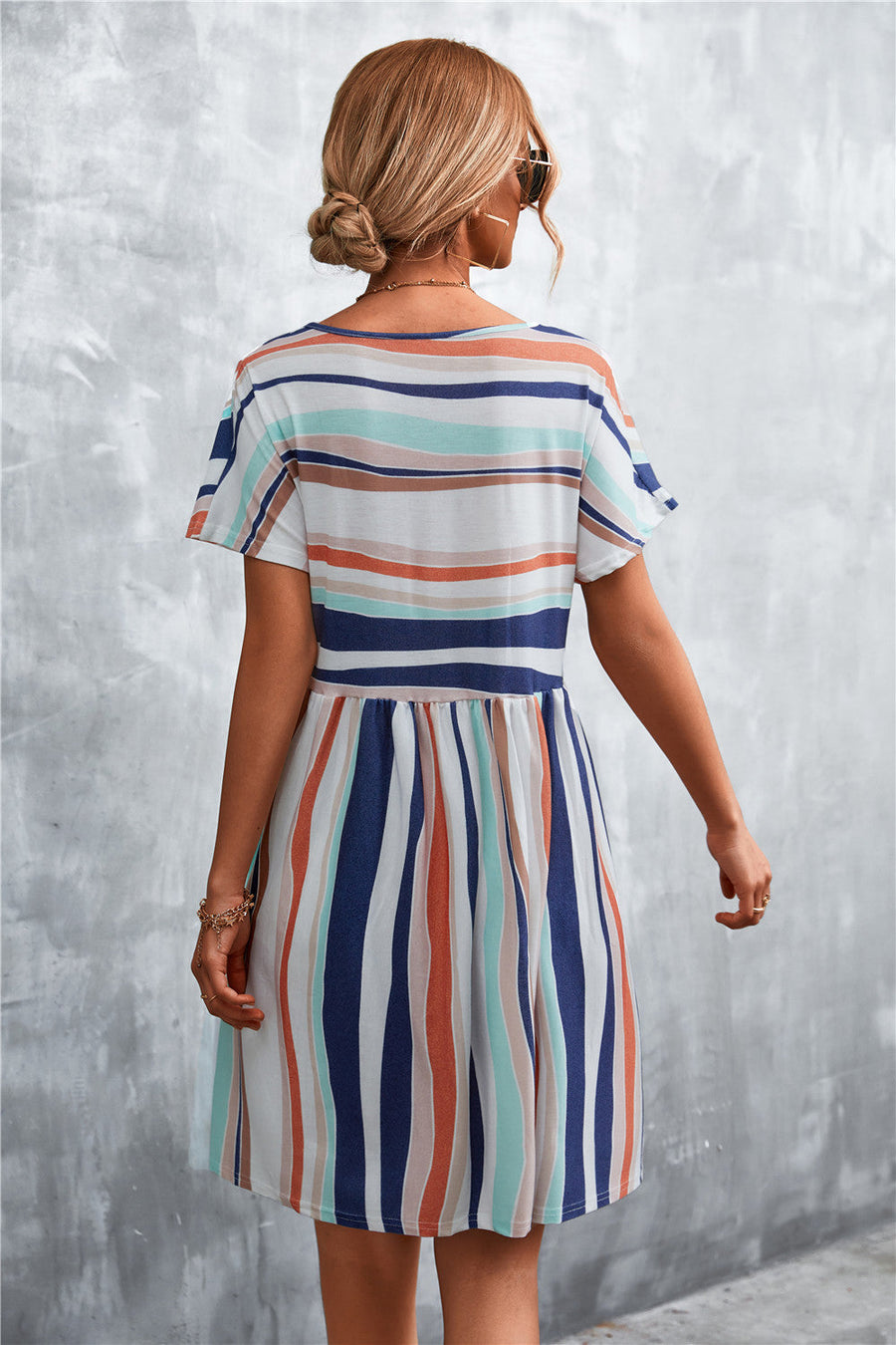 Striped trapeze dress with short sleeves and a gathered waist, featuring horizontal and vertical stripes in coral, navy, and