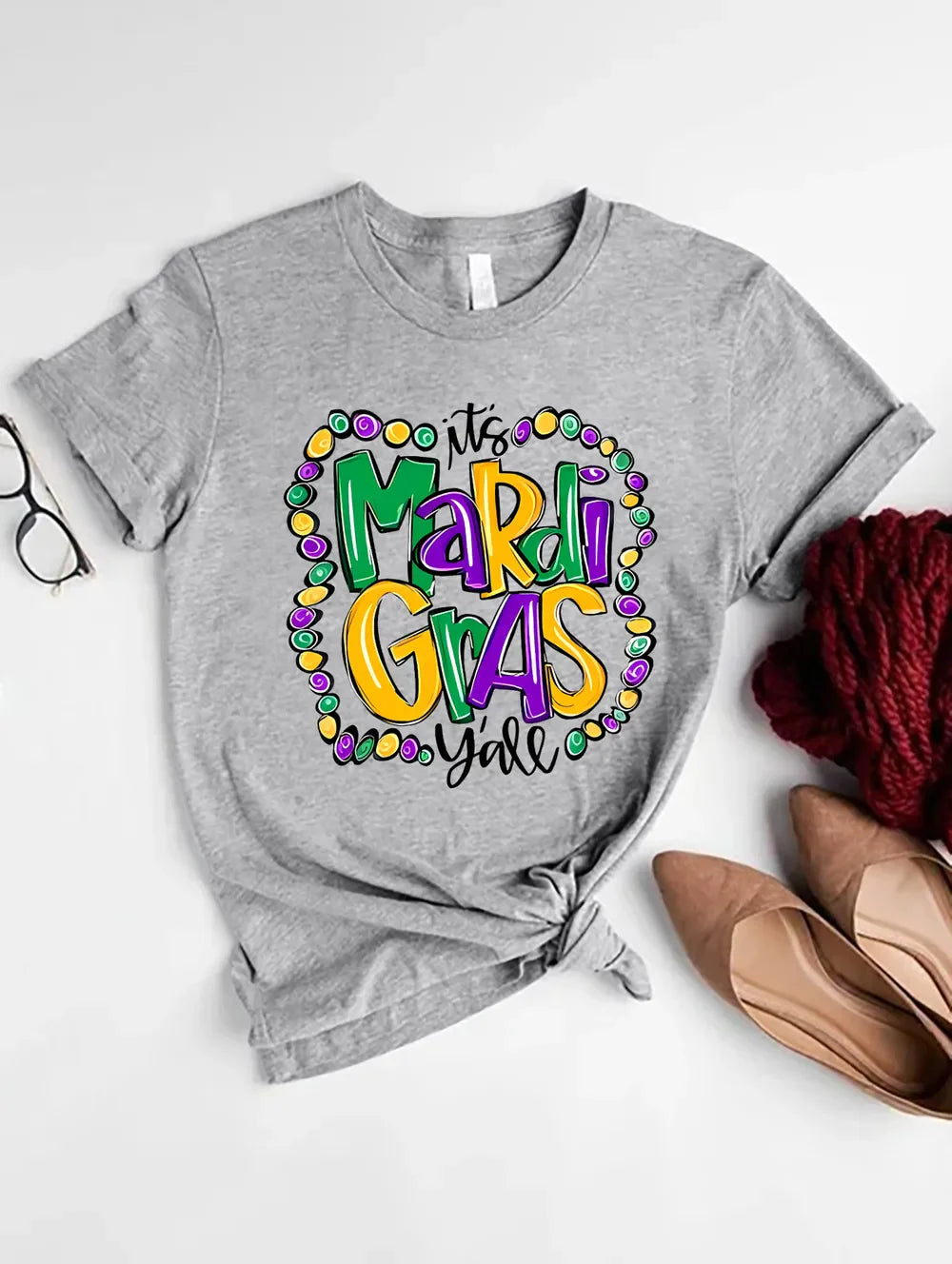 Women's gray Mardi Gras graphic t-shirt with "It's Mardi Gras Y'all" text.