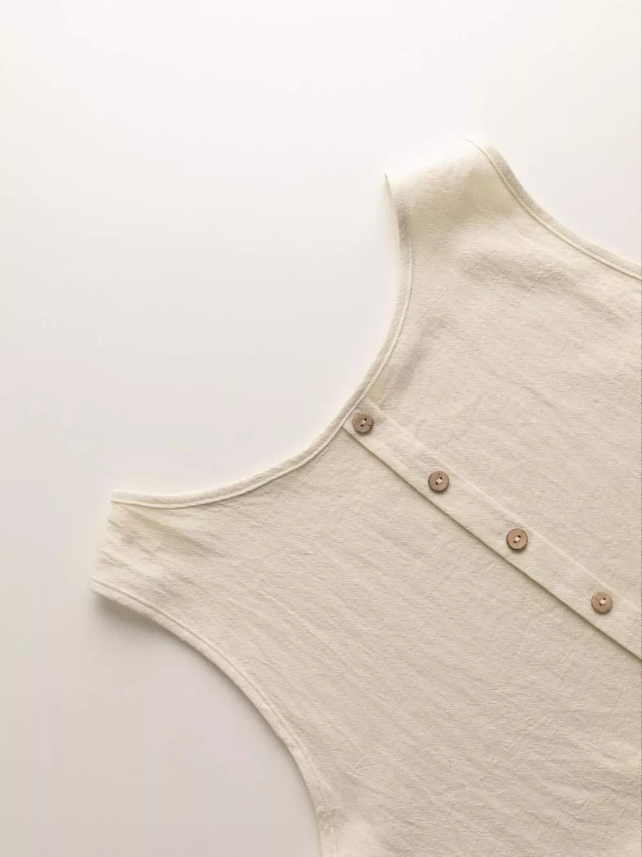 Beige sleeveless peplum top with button front detail and wide-leg pants set