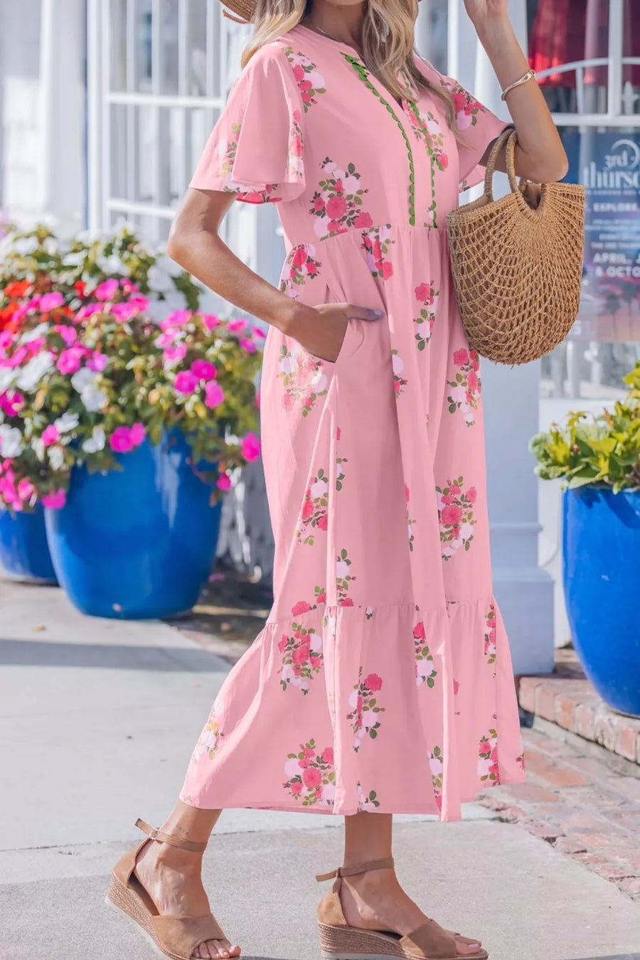 Pink floral cotton midi dress with flutter sleeves and tiered hem.