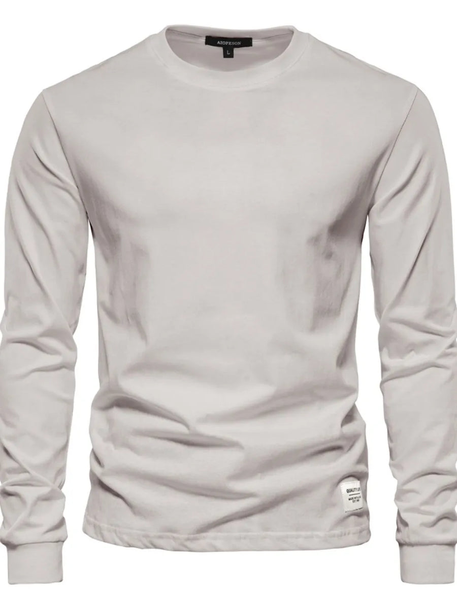 Light Gray crewneck long sleeve t-shirt with a small tag detail on the hem.