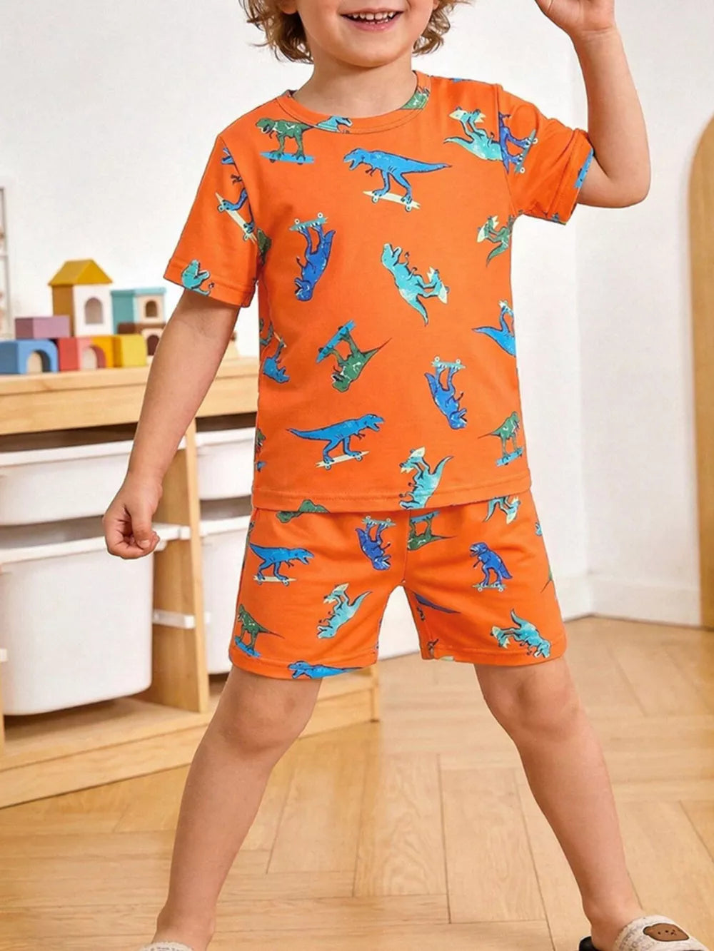 Orange toddler tee and shorts set with skateboarding dinosaur print