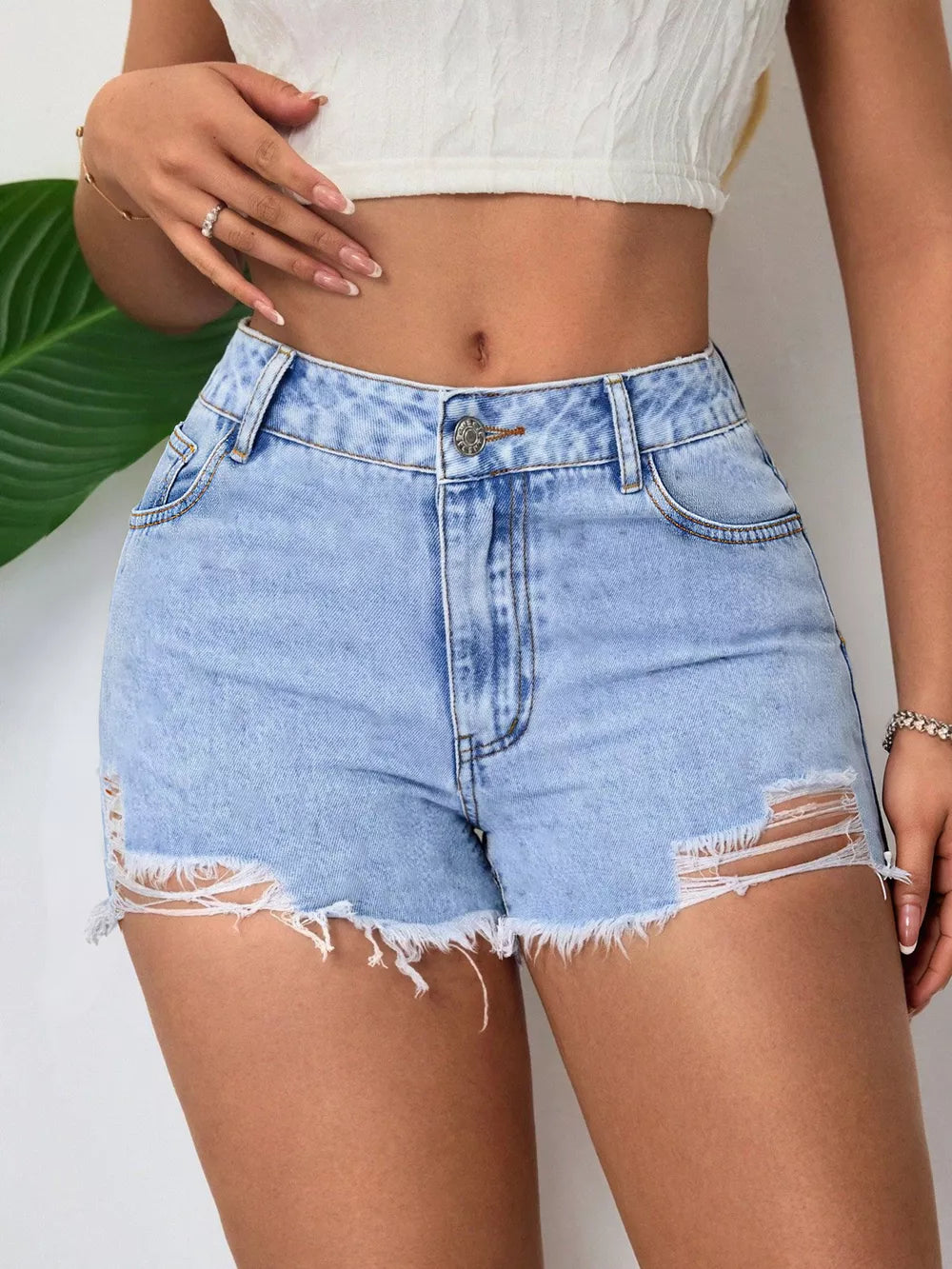 Light wash denim shorts with frayed hem and distressed rips