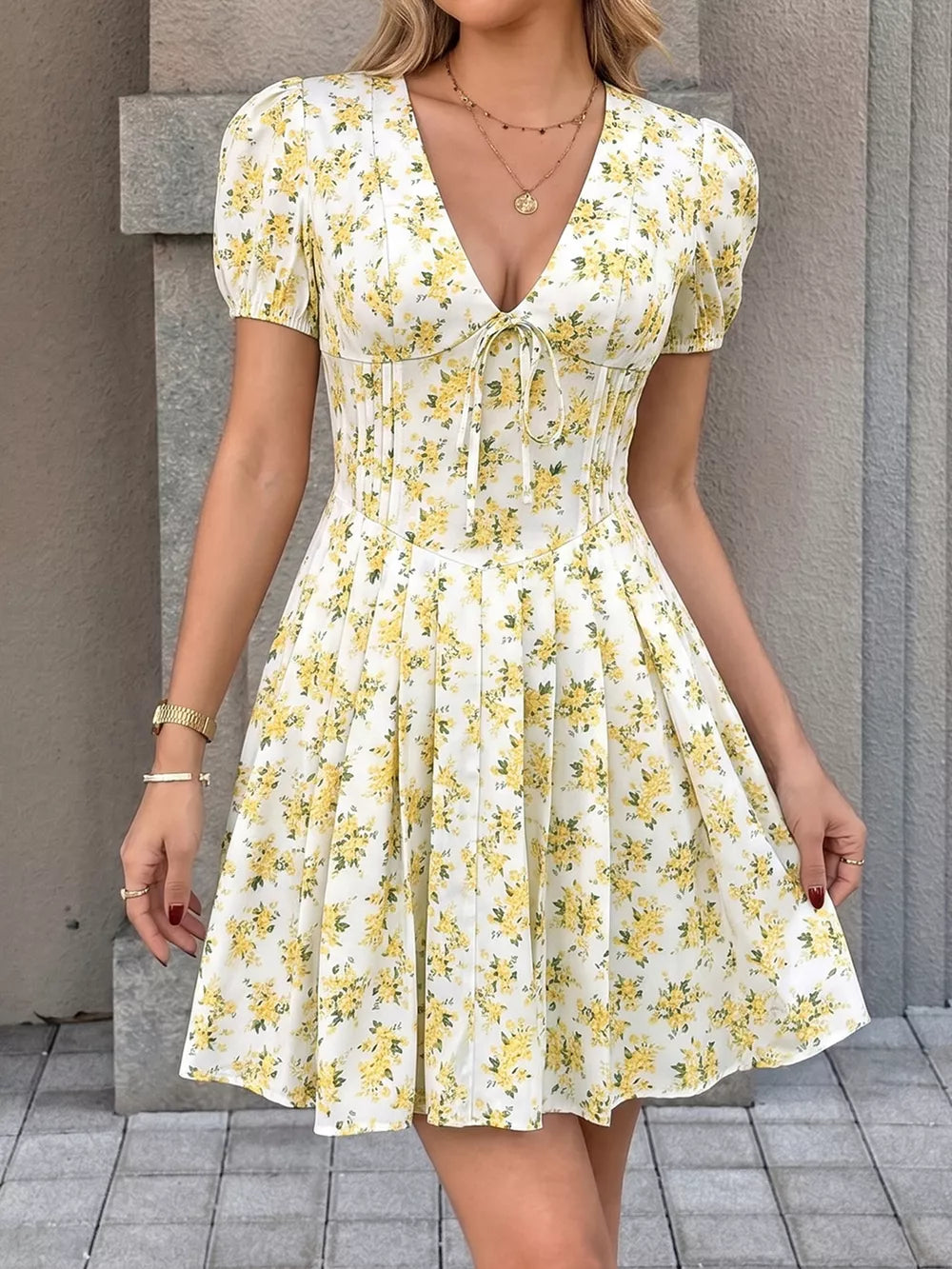 White floral print mini dress with puff sleeves, V-neck, and tie front detail.