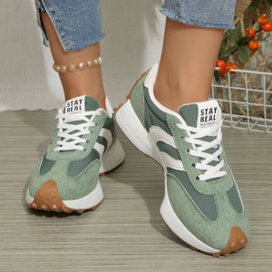 Green and white lace up round toe sneakers with chunky sole and brown toe detail.