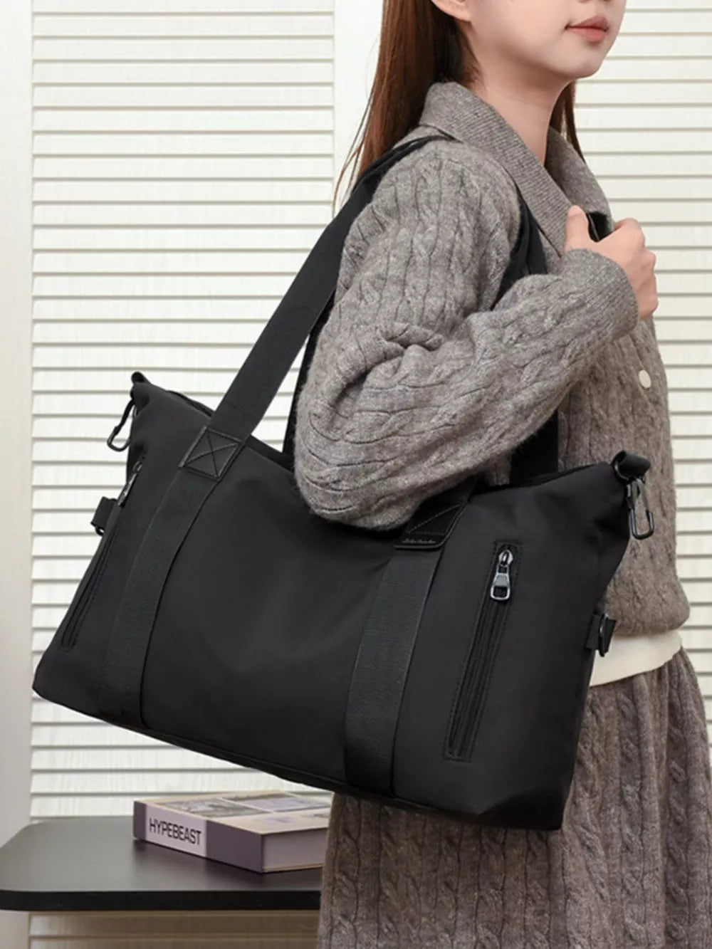 Black Oxford cloth travel bag with multiple zippered pockets and adjustable strap.