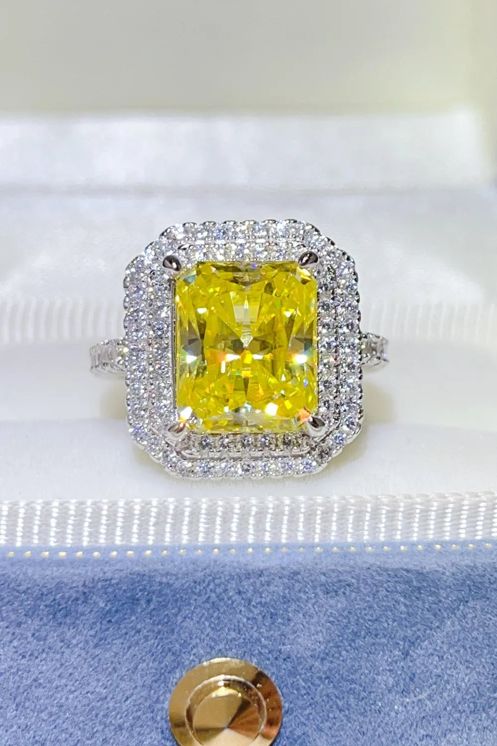 Yellow radiant cut halo ring with canary moissanite center stone and diamond accents.