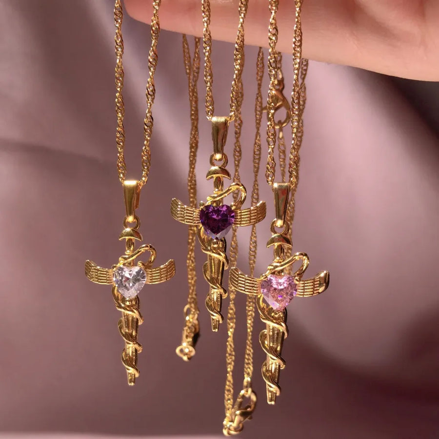 18K gold-plated cross charm necklaces with heart-shaped gemstones in clear, purple, and pink.