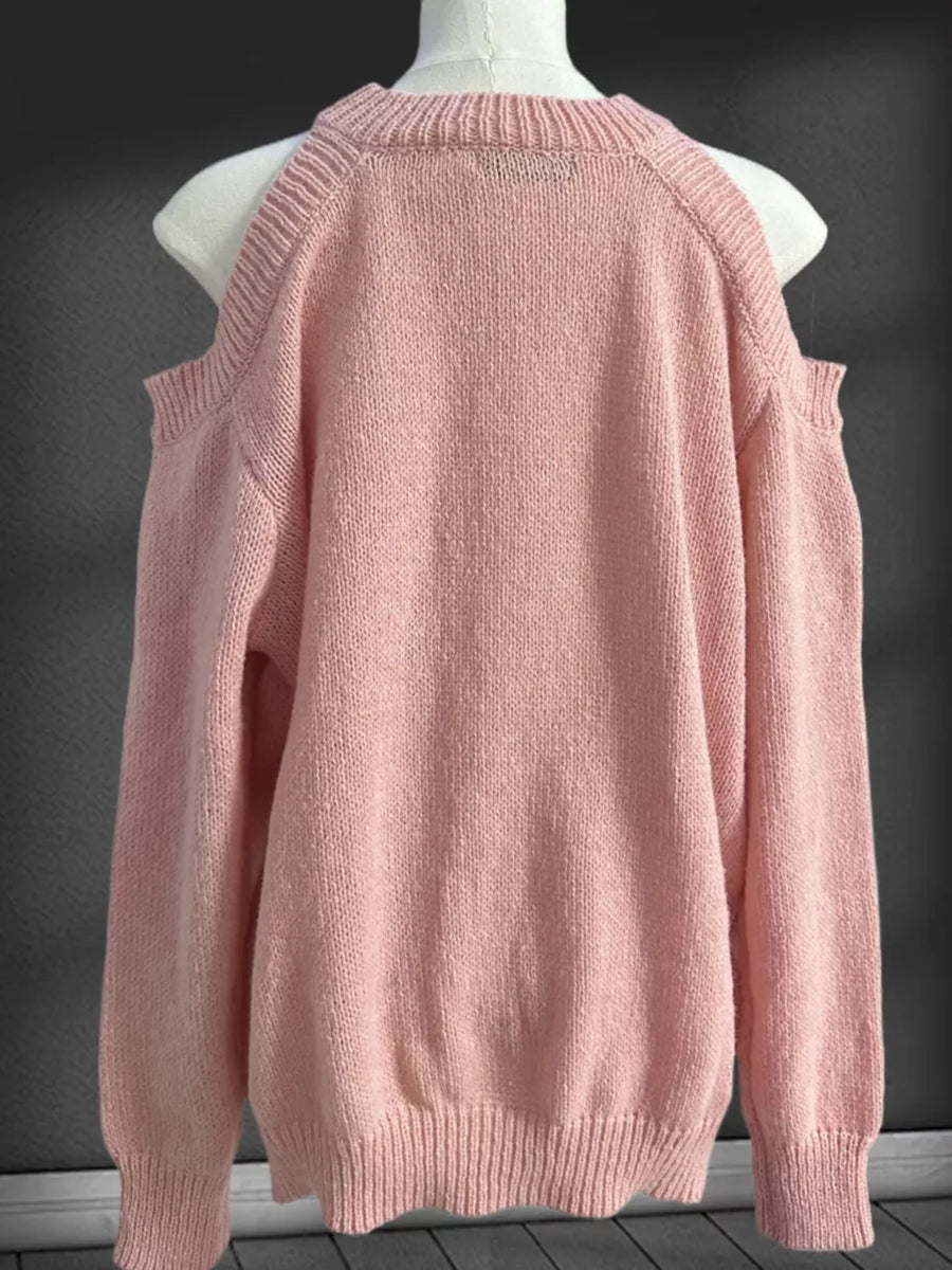 Pink cold shoulder knit sweater with crew neck and ribbed cuffs and hem.