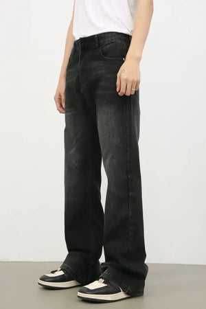 Dark wash denim trousers with exaggerated flare, styled with sneakers.