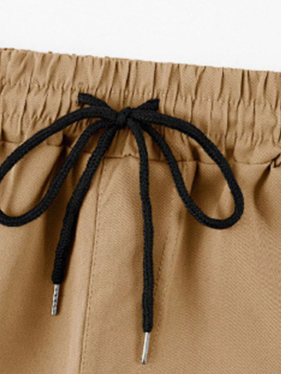 Khaki cargo pants with adjustable drawstring waist and metal-tipped cords.