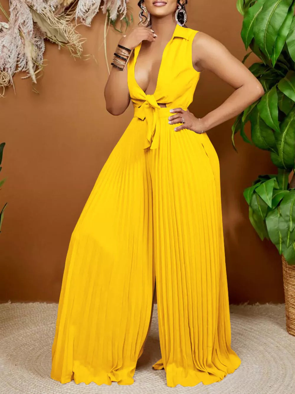 Yellow collared sleeveless romper with tie front and pleated wide legs.