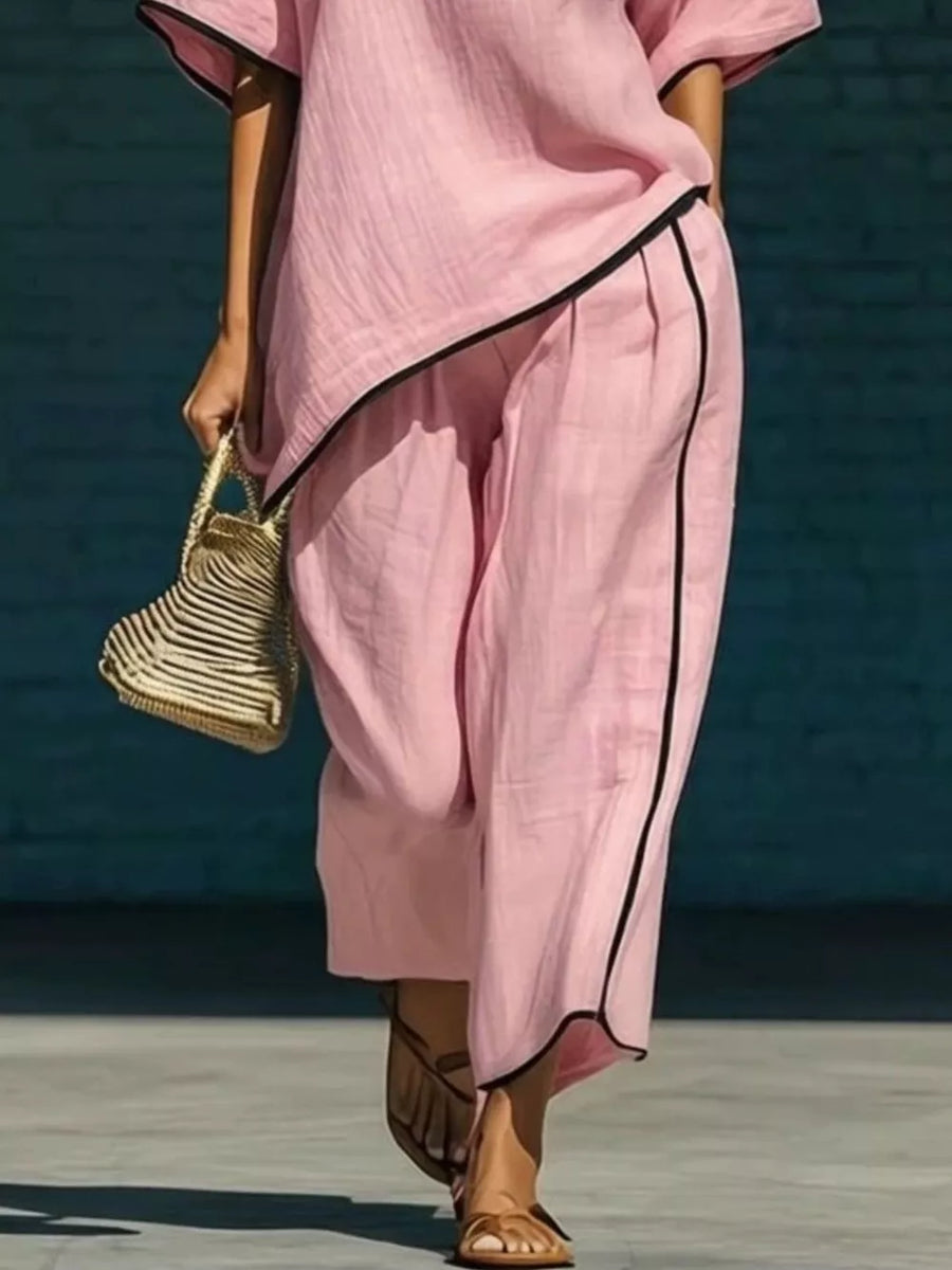 Pink two-piece set with contrast trim, half sleeves, and wide-leg pants.