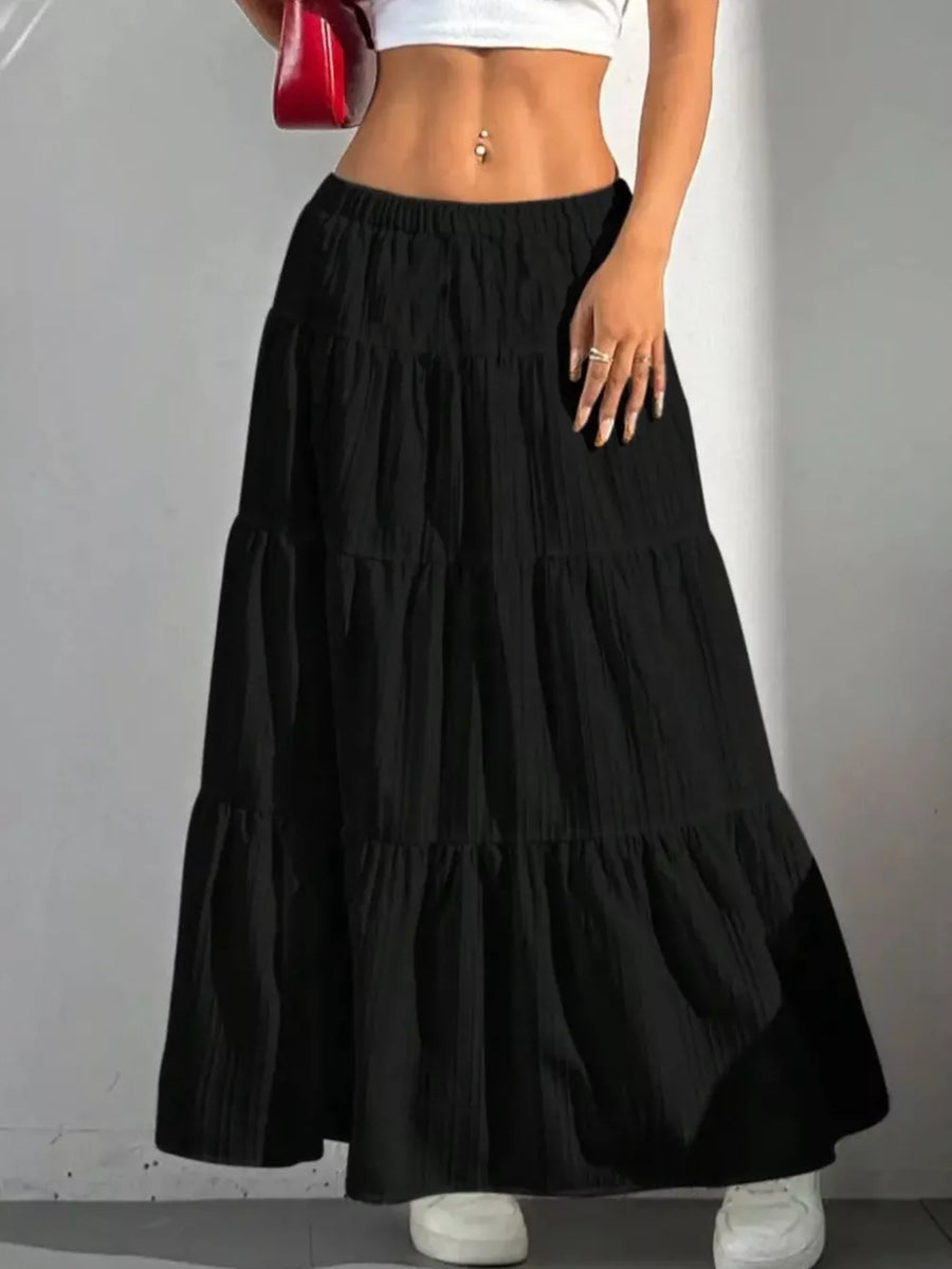 Black tiered maxi skirt with elastic waistband and textured fabric.