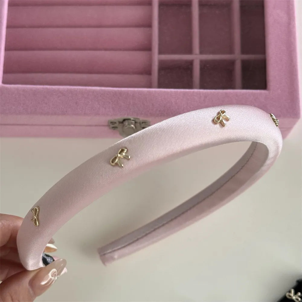 Padded satin headband in pink with gold bow embellishments