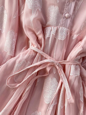 Pink chiffon maxi dress with floral embroidery and a belted waist.