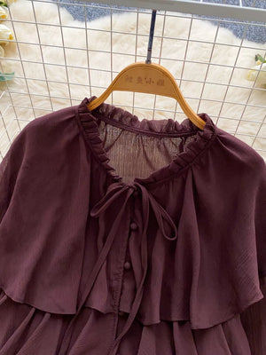 Brown chiffon blouse with ruffled neckline, bow tie, and button front.