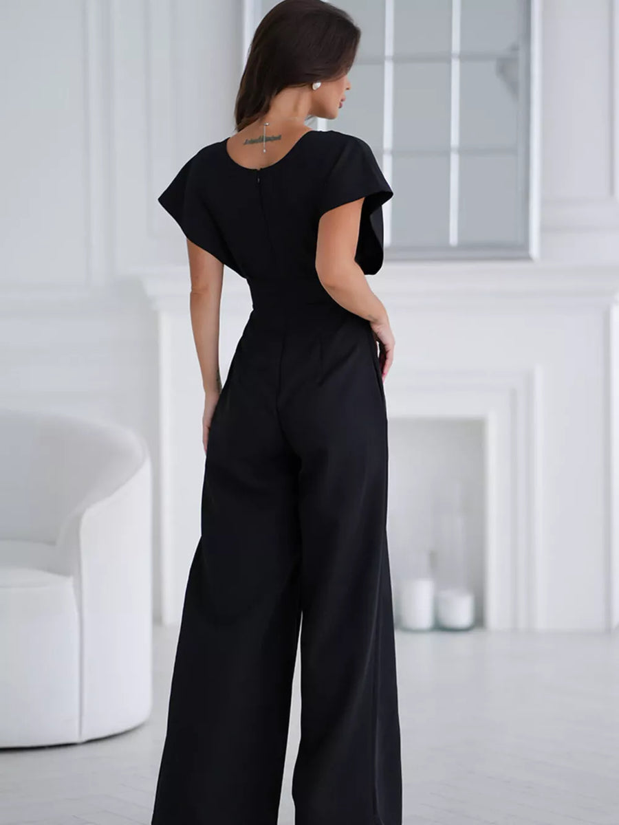 Black wide-leg romper with flutter sleeves and surplice neckline, shown from the back.
