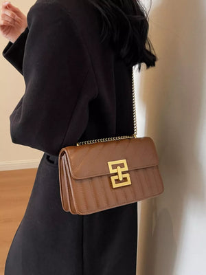 Chic quilted crossbody bag in brown with gold chain strap and clasp.