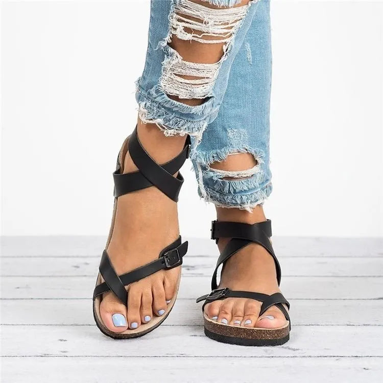 Black crisscross strap cork footbed sandals with buckle ankle strap.