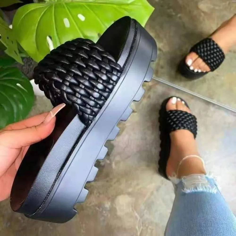 Black woven platform slide sandals with thick lug sole.