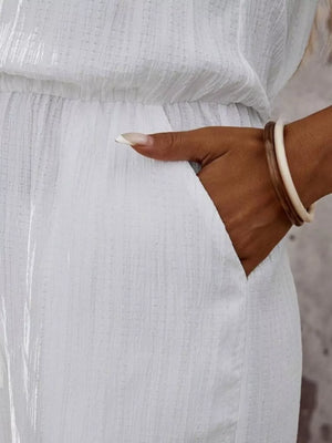 White crinkled wide-leg jumpsuit with pockets and elastic waist.