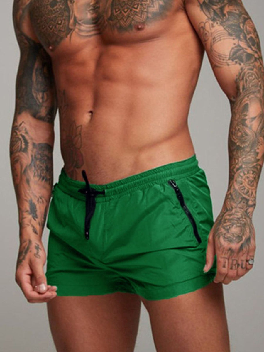Green swim shorts with drawstring and zippered pockets