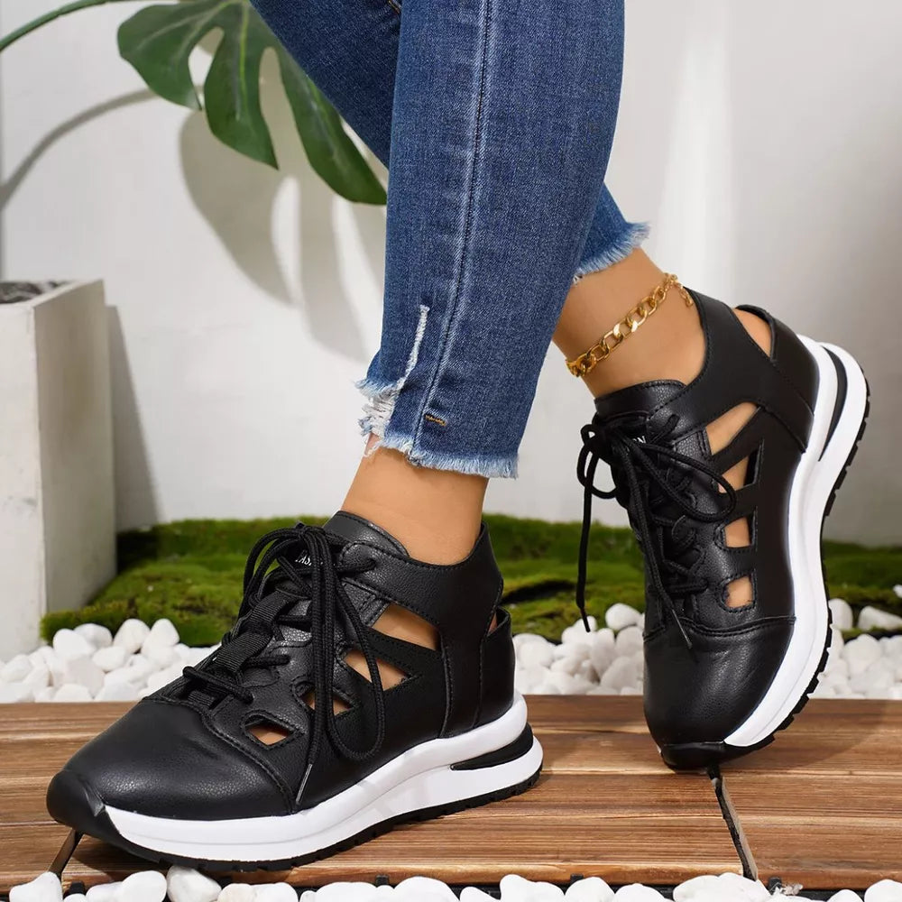 Chic black round toe lace-up sneakers with cut-out details and white soles.
