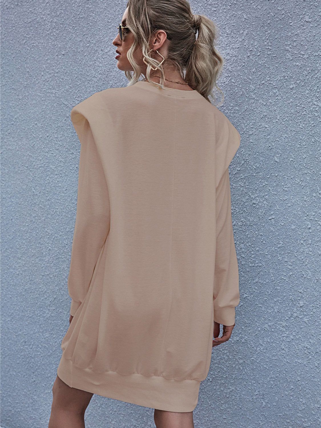 Tan sweatshirt mini dress with padded shoulders and long sleeves.