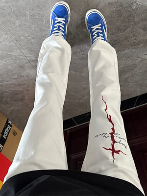 White casual sweatpants with red graphic print detail on the leg.