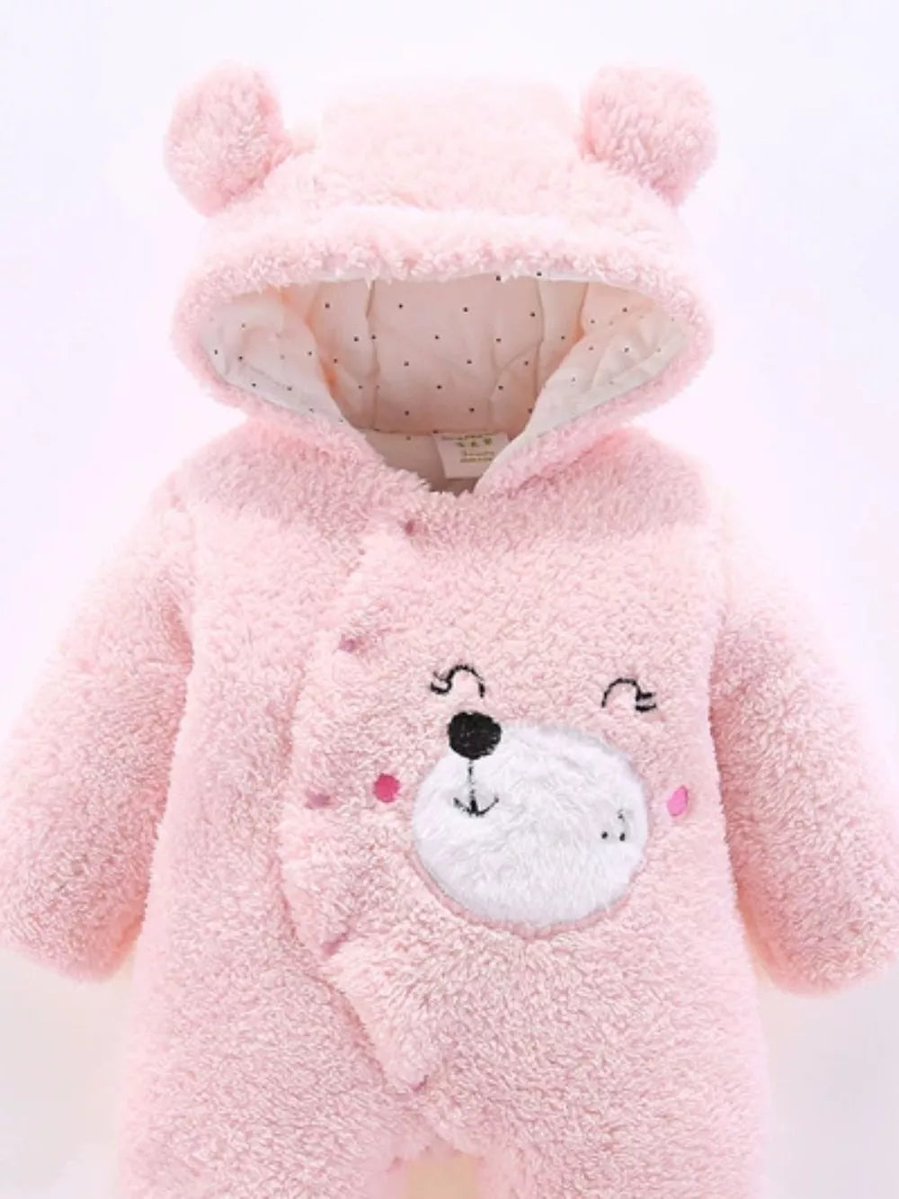 Blush pink hooded one-piece baby romper with bear ears and embroidered bear face detail.