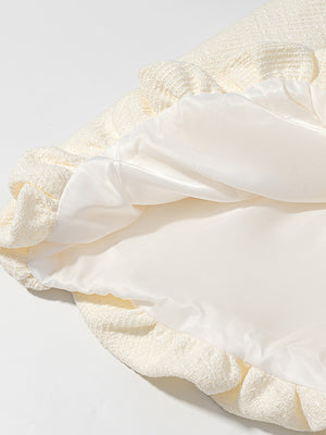 Cream textured button-down top with a satin lining and bubble hem detail.
