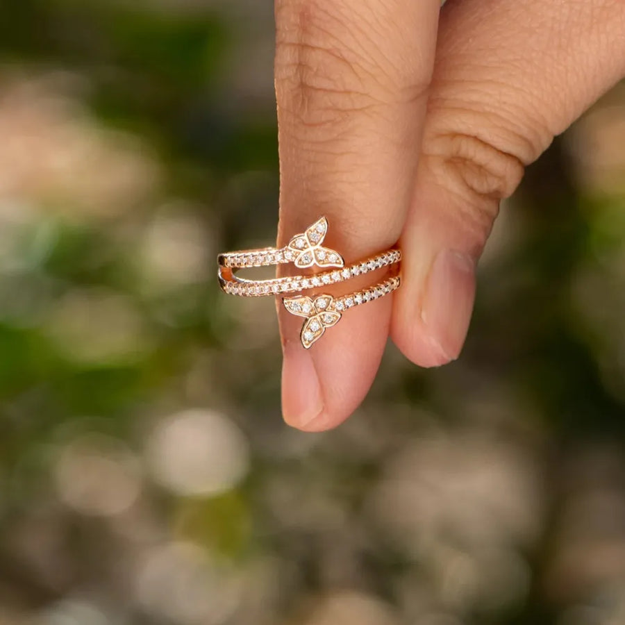 Gold bypass ring with two diamond-accented butterfly details.