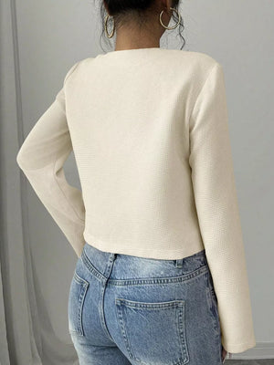 Cream textured long sleeve cropped top with a crew neck.