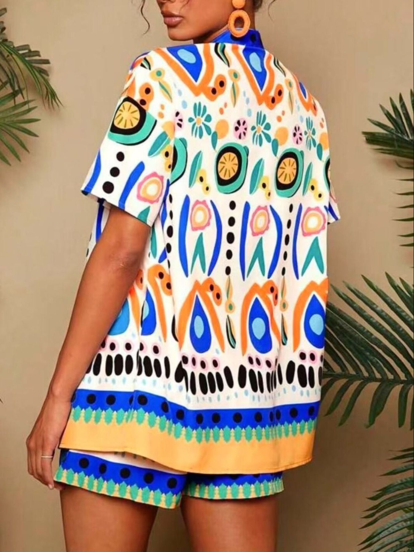 Women's tropical print short sleeve cardigan and shorts set in white with blue, orange, and green abstract patterns.
