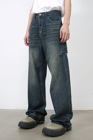 Baggy dark navy denim jeans with knee slits and distressed details.