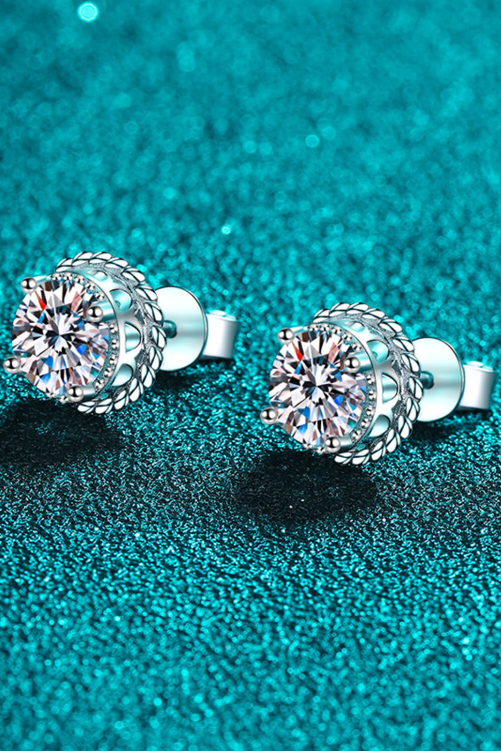 Silver rope-framed moissanite stud earrings with brilliant cut stones.
