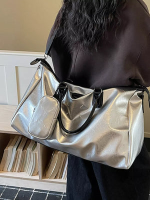 Sleek silver metallic large travel bag with adjustable strap and front pouch.