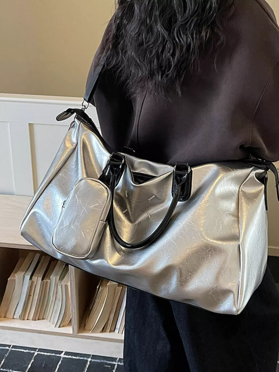 Sleek silver metallic large travel bag with adjustable strap and front pouch.