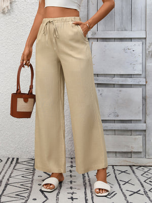 Apricot high-waist wide-leg pants with drawstring and pockets.