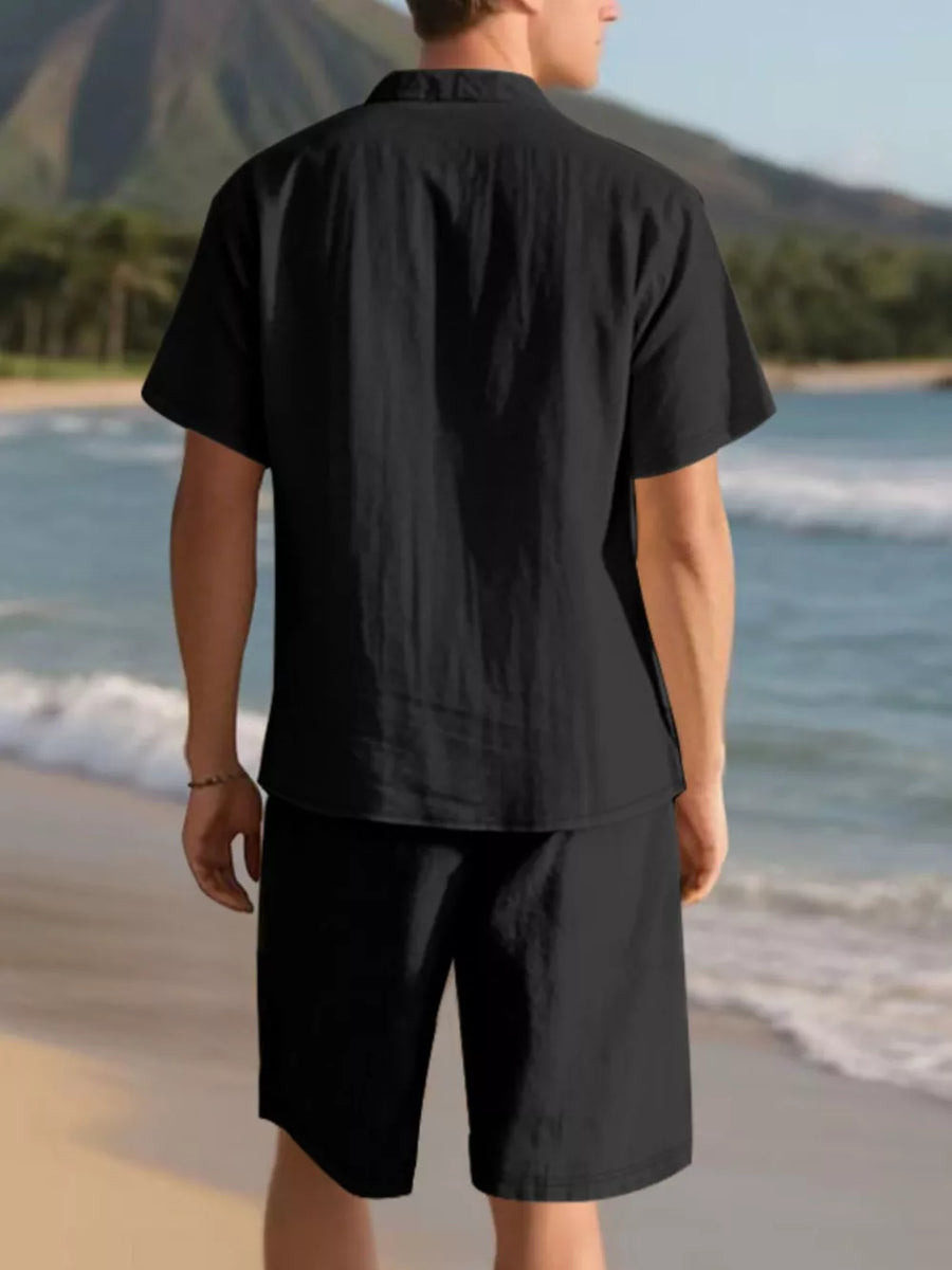 Black men's casual short sleeve shirt and shorts ensemble on beach