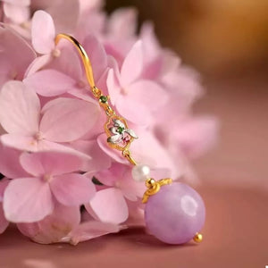 Elegant purple drop earrings with pearl and floral charm detail