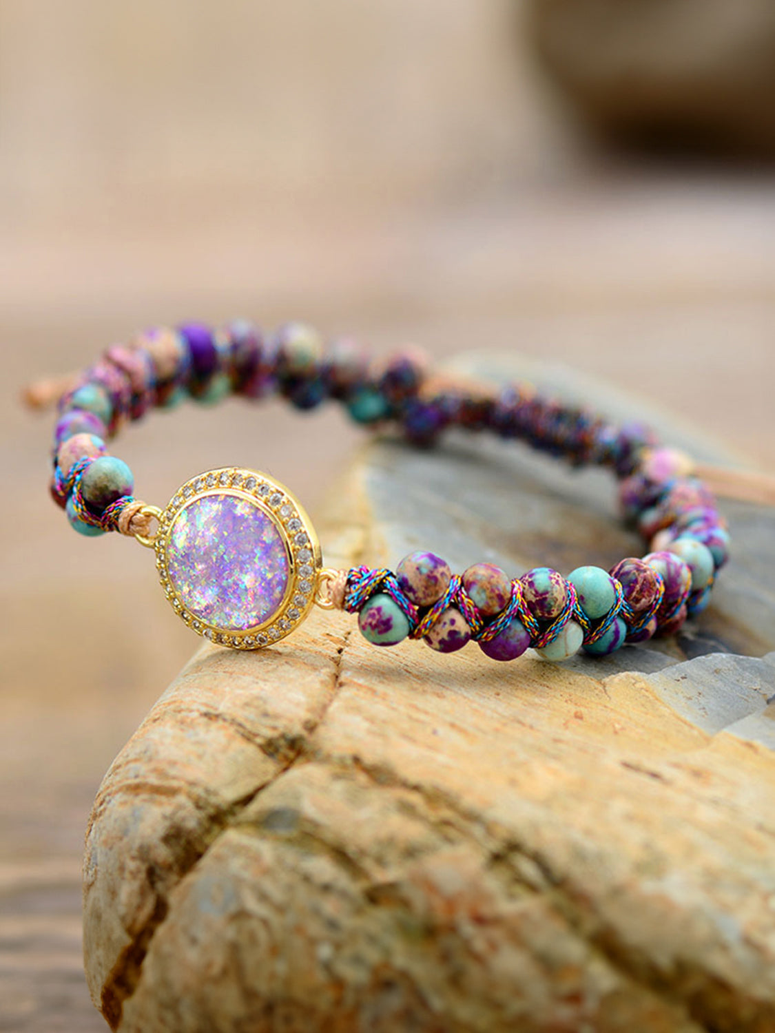 Multicolor beaded bracelet with iridescent orb and jasperite beads, gold accent.