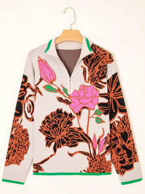 Knit quarter zip sweater with floral print, stand neck, and green trim.